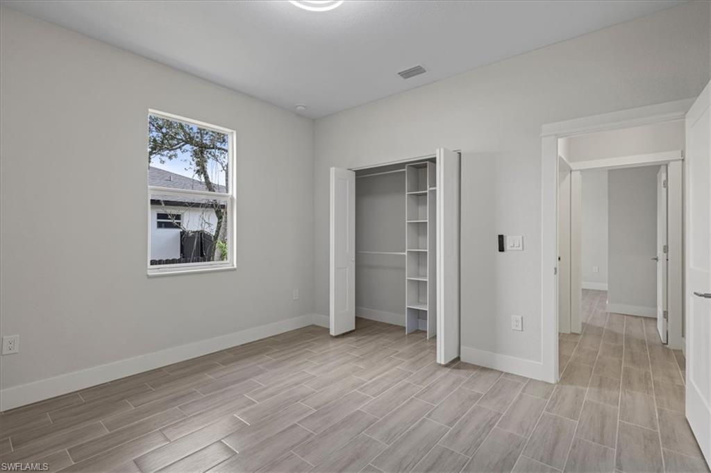 Unfurnished bedroom featuring wood finish floors and a closet