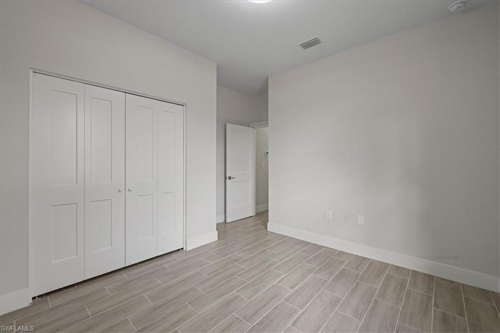 Unfurnished bedroom featuring a closet and wood tiled floors