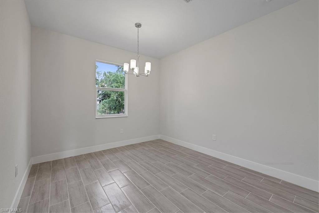 Empty room featuring a chandelier and wood tiled floors