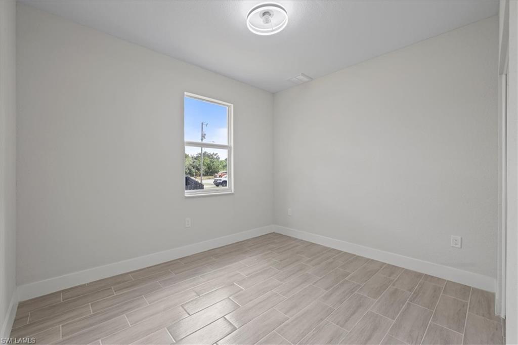 Empty room featuring baseboards and wood finish floors