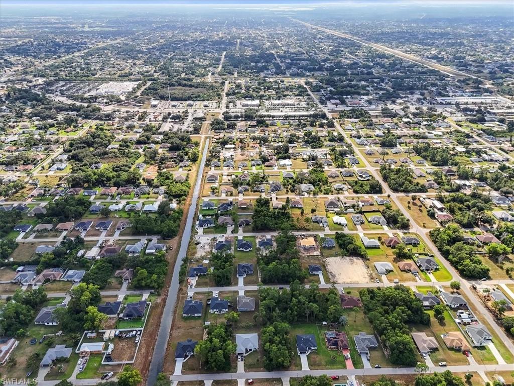 Aerial view of property and surrounding area featuring nearby suburban area