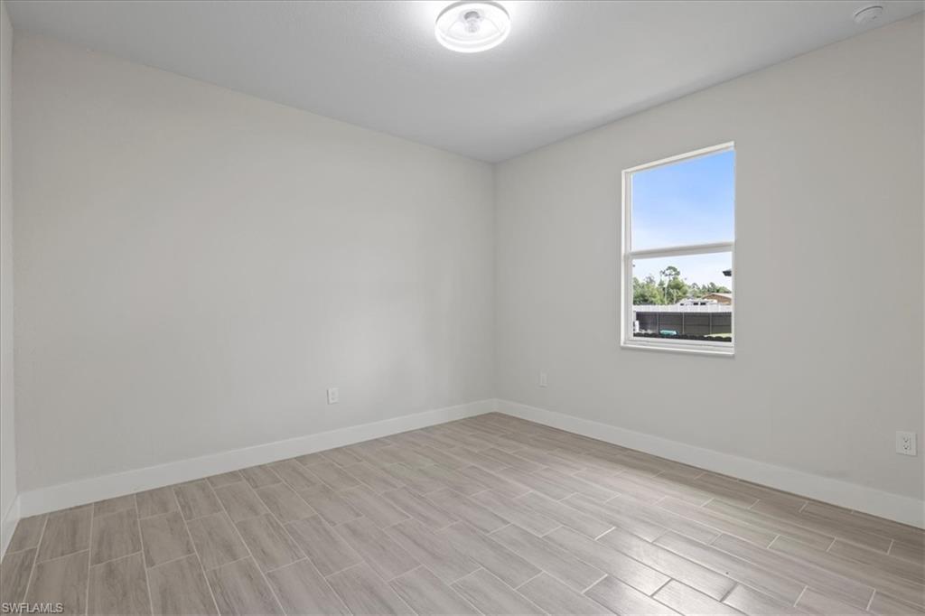 Spare room with baseboards and wood finish floors
