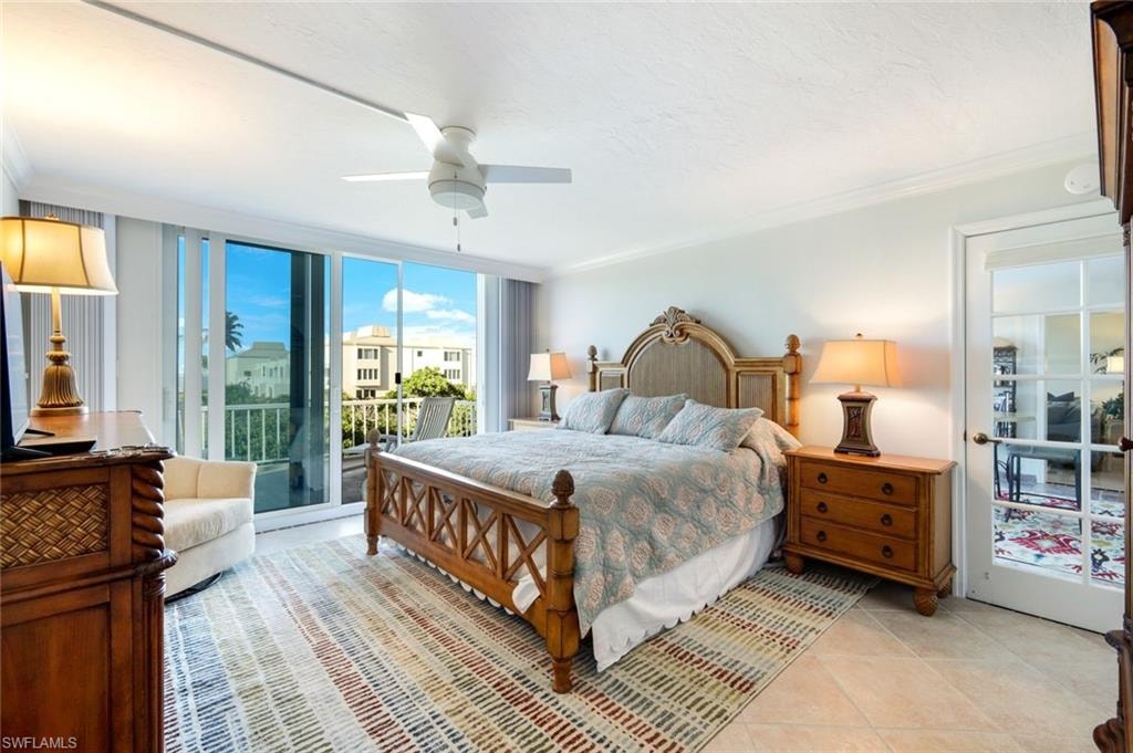 Bedroom with access to outside, crown molding, a ceiling fan, light tile patterned floors, and a wall of windows