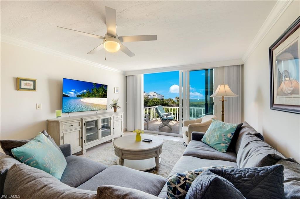 Living area featuring crown molding, a wall of windows, and a ceiling fan