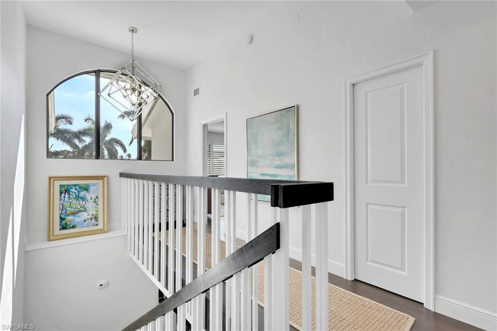 Hallway featuring an upstairs landing and dark wood finished floors