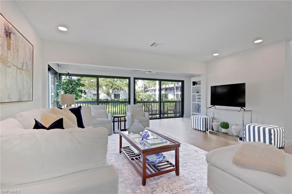 Living room with wood finished floors, plenty of natural light, and recessed lighting
