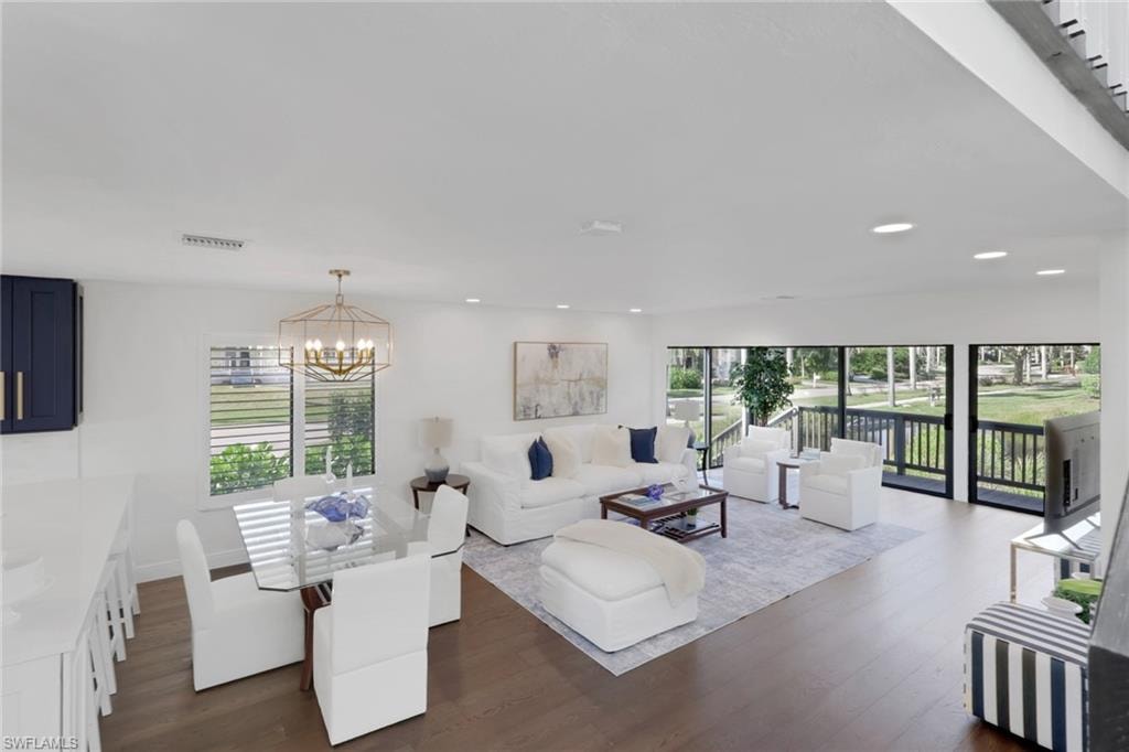 Living area with dark wood-style floors and a chandelier