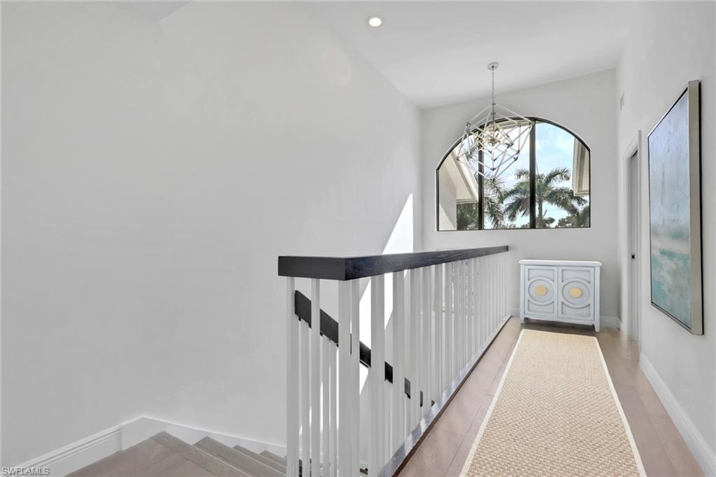Hall featuring an upstairs landing and a chandelier