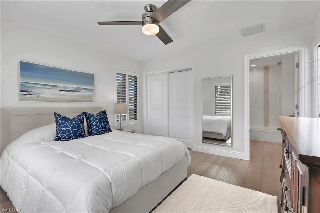 Bedroom with light wood-type flooring, a closet, and a ceiling fan