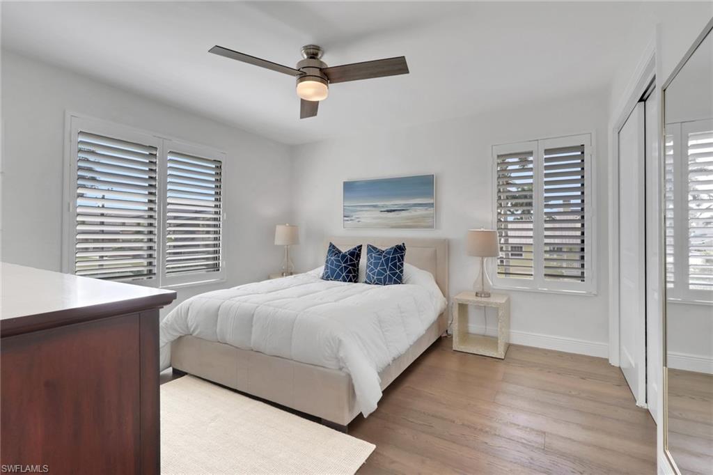 Bedroom with light wood-style floors, a closet, and ceiling fan
