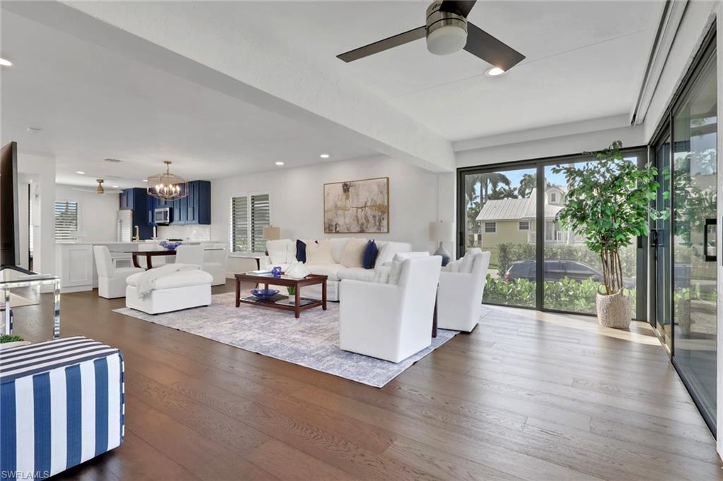 Living room with a chandelier, healthy amount of natural light, recessed lighting, dark wood finished floors, and a ceiling fan