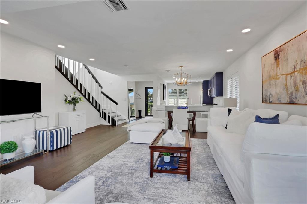 Living room featuring wood finished floors, recessed lighting, stairway, and a chandelier