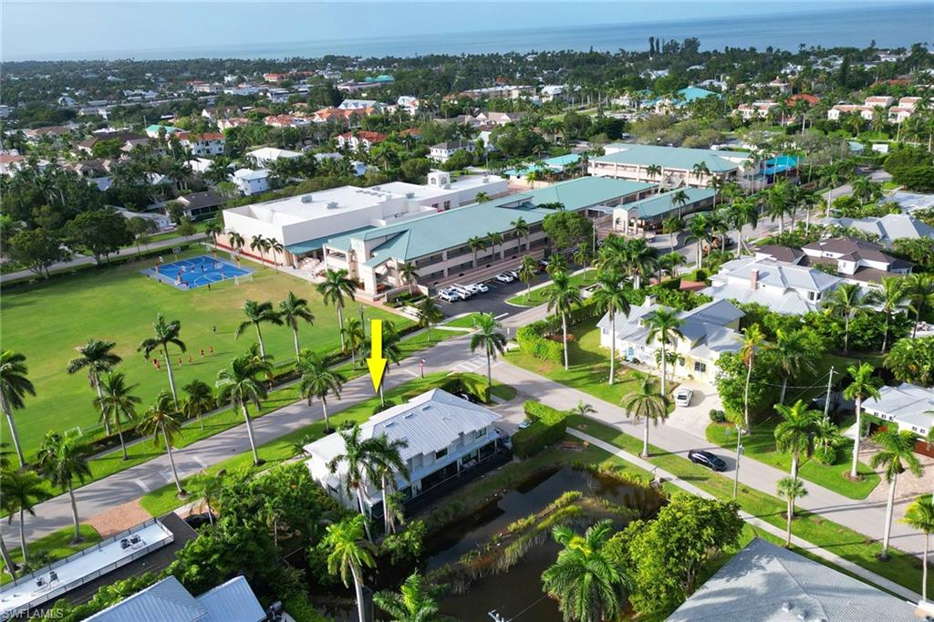 Aerial view of property and surrounding area featuring a nearby body of water and nearby suburban area