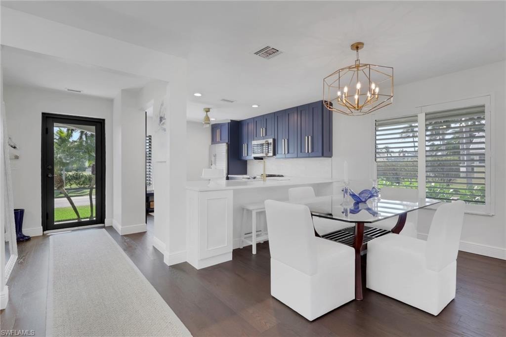 Dining area featuring dark wood-type flooring, a chandelier, and recessed lighting