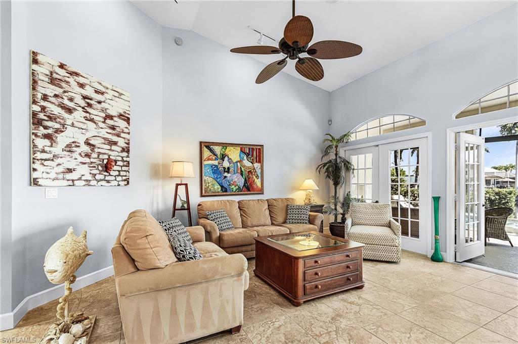 Living area featuring high vaulted ceiling, ceiling fan, and french doors
