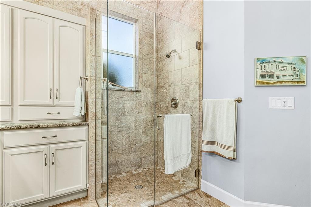 Bathroom featuring a shower stall and baseboards