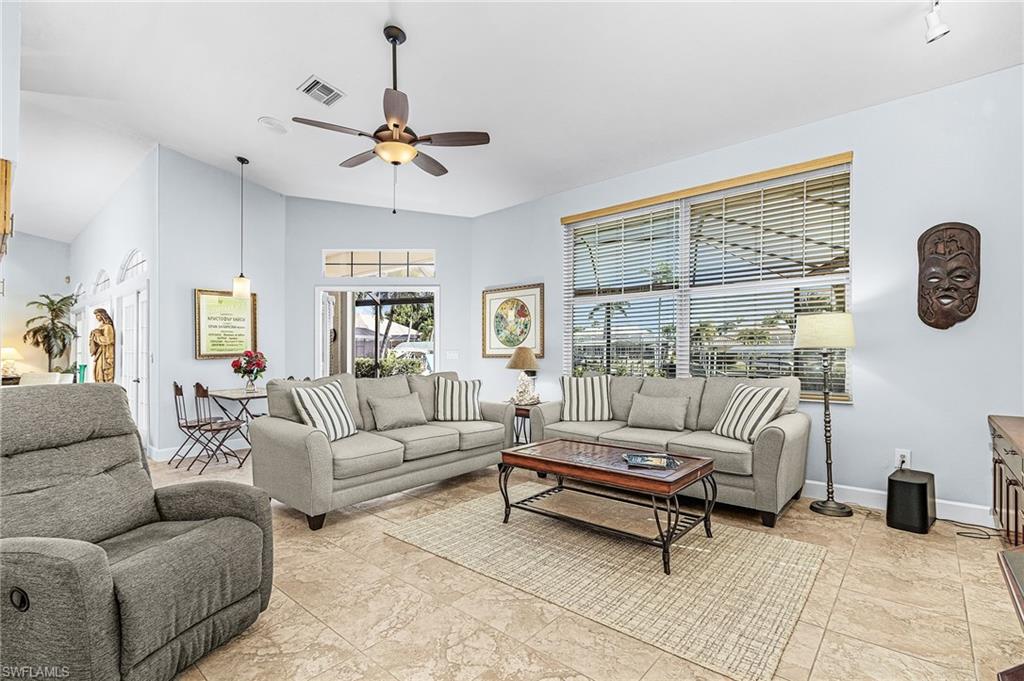 Living room with a ceiling fan and lofted ceiling