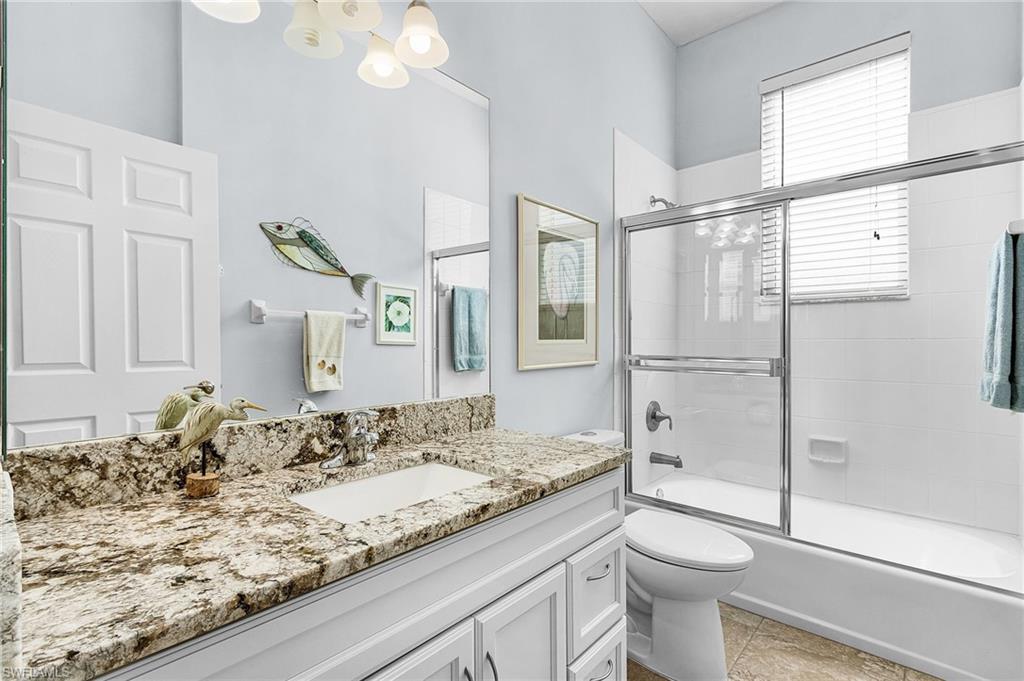 Bathroom with combined bath / shower with glass door and vanity