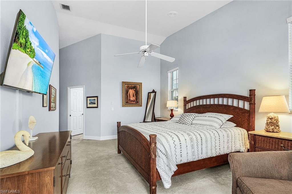 Bedroom featuring light carpet, high vaulted ceiling, and a ceiling fan