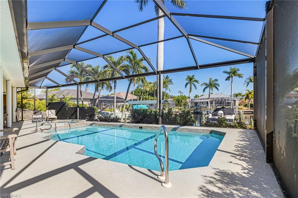 View of swimming pool featuring a patio, a lanai, a sunroom, and a pool with connected hot tub