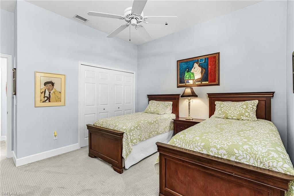 Bedroom with a closet, light carpet, and a ceiling fan