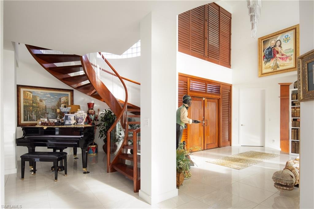 Entrance foyer featuring stairway, tile patterned floors, and a towering ceiling