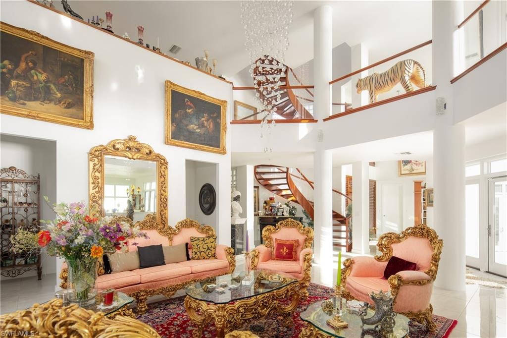 Tiled living area featuring stairway and a high ceiling