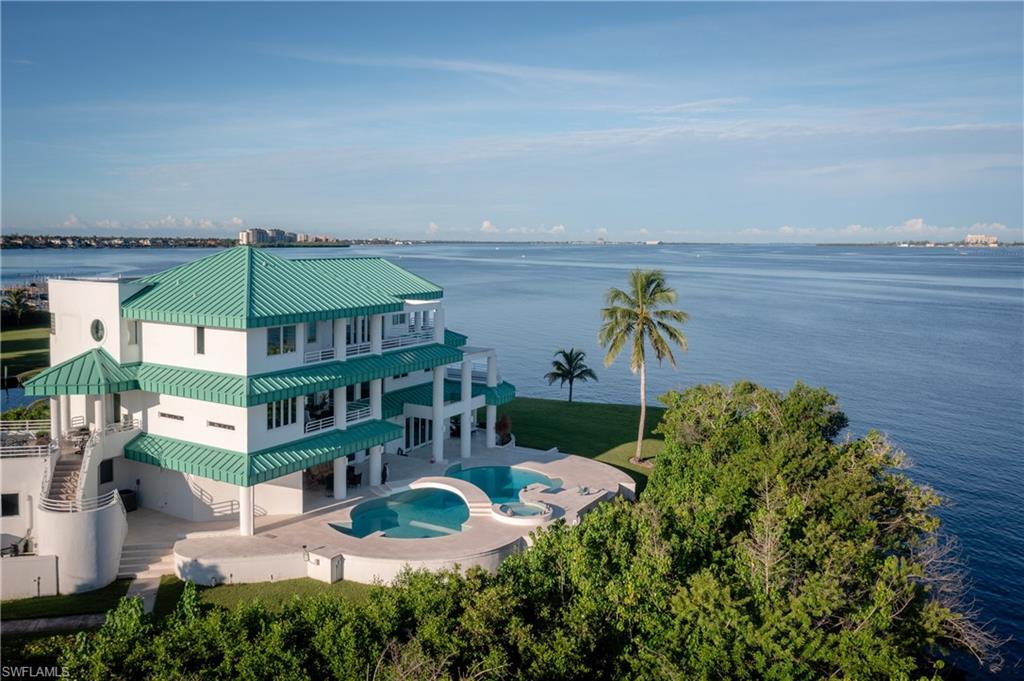 Aerial view of property and surrounding area featuring a large body of water and a pool