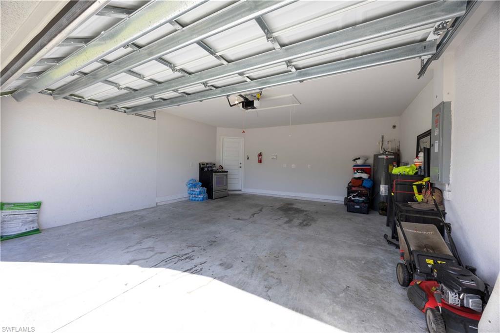 Garage featuring electric water heater and electric panel