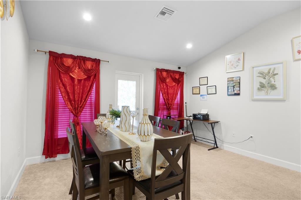 Dining room featuring vaulted ceiling, light carpet, and recessed lighting