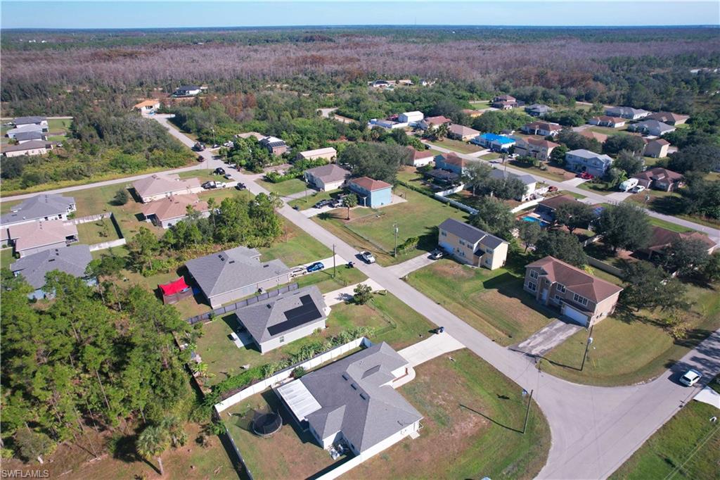 Aerial view of property and surrounding area featuring nearby suburban area