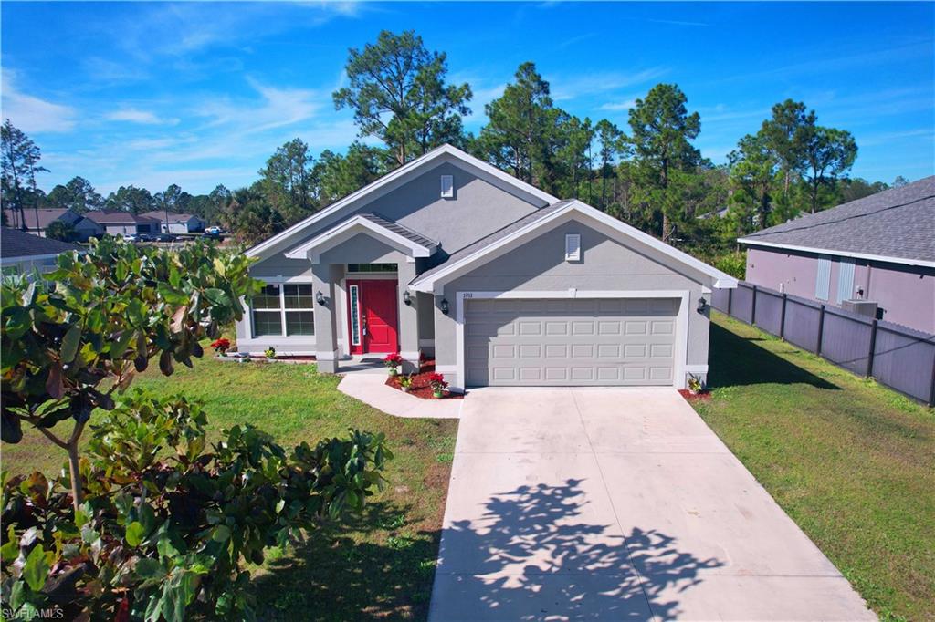 Ranch-style house with concrete driveway, a garage, and stucco siding
