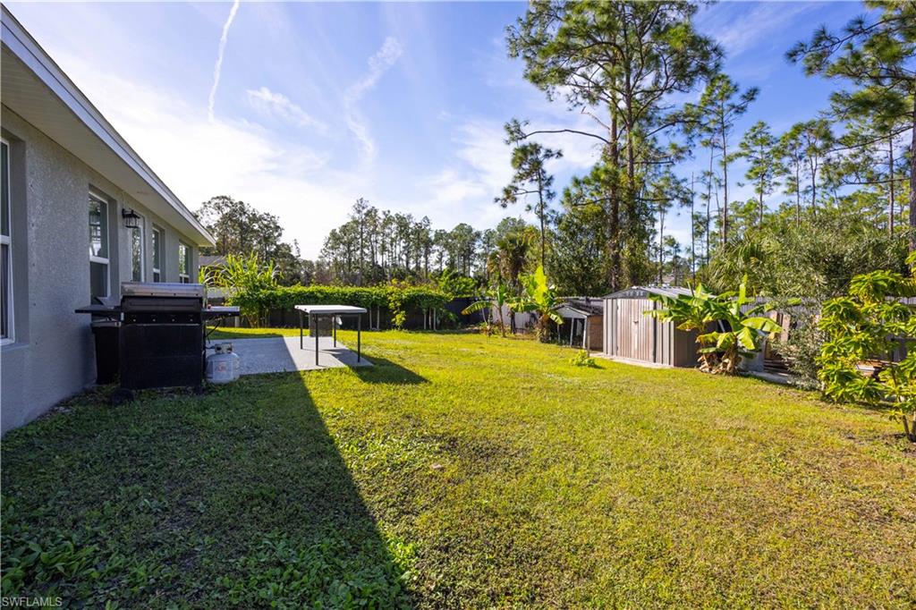 Fenced backyard featuring a shed and a patio area