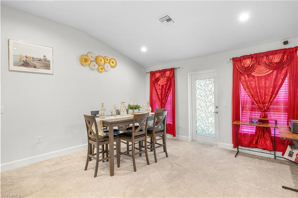 Dining space featuring lofted ceiling, light carpet, and recessed lighting