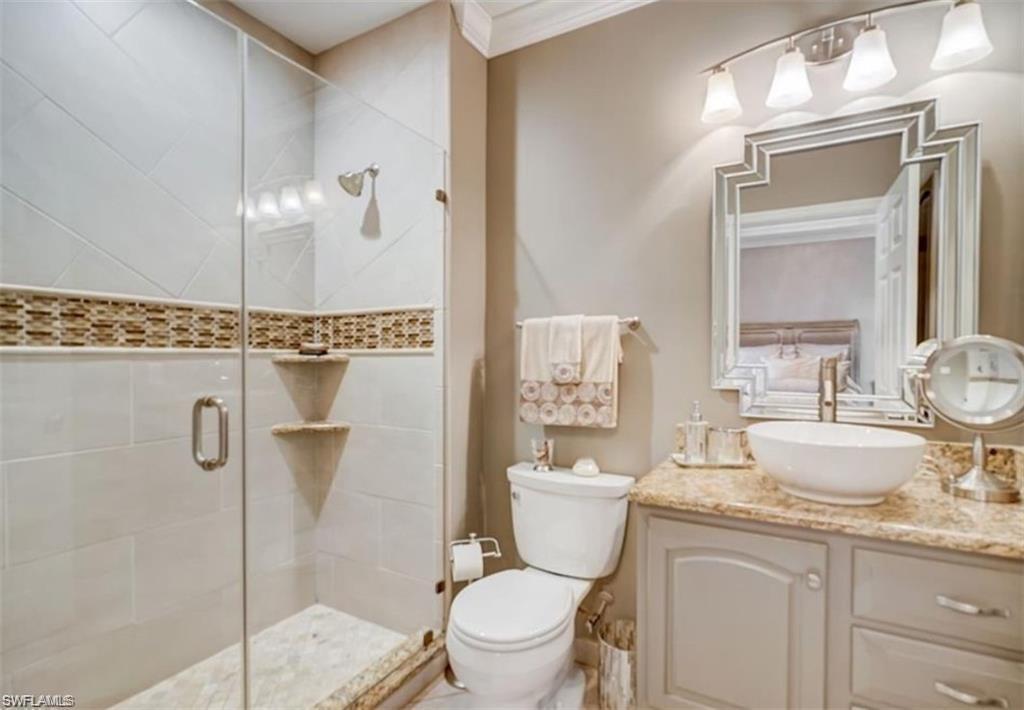 Full bath featuring crown molding, vanity, and a shower stall
