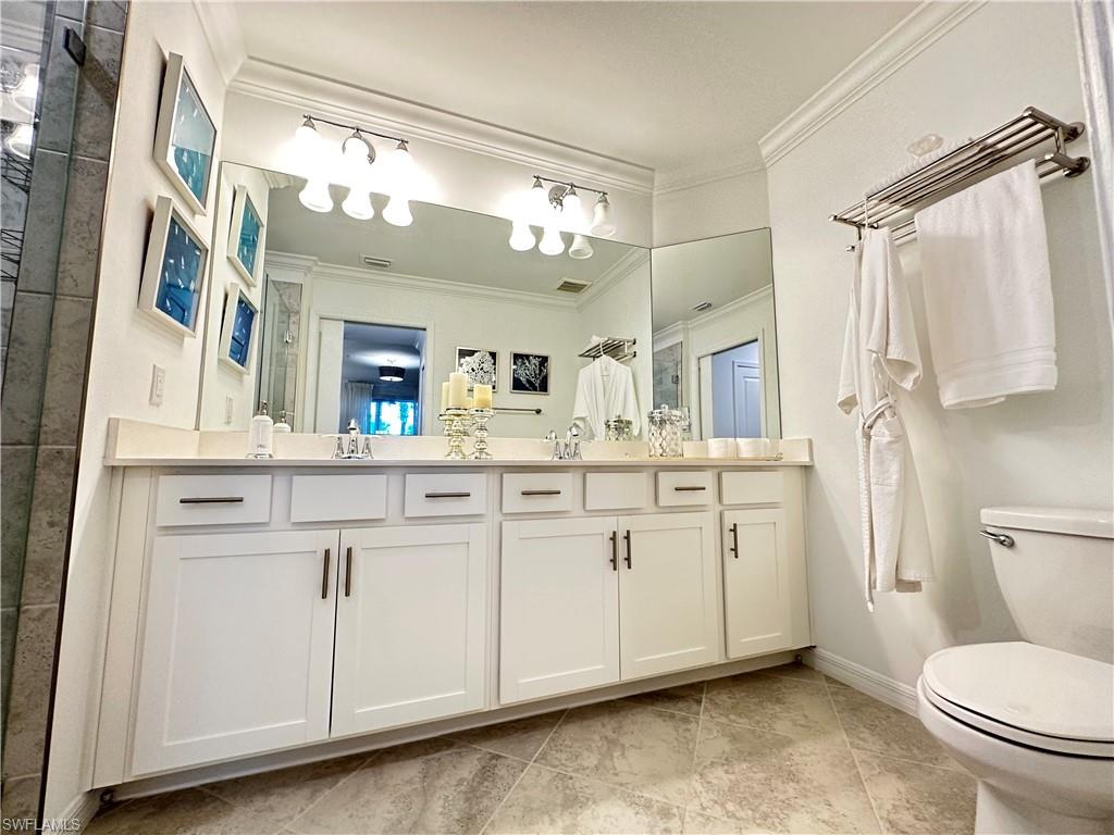 Bathroom featuring toilet, tile patterned flooring, and crown molding