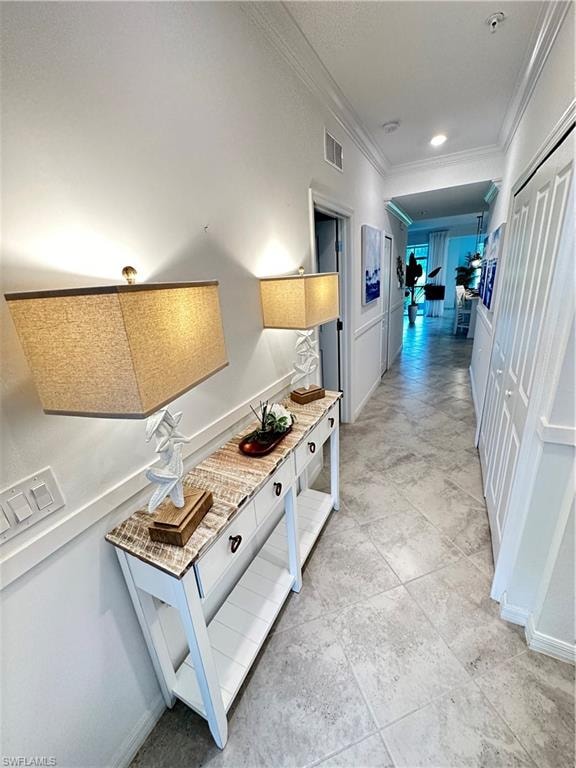 Hallway featuring light tile patterned floors and crown molding