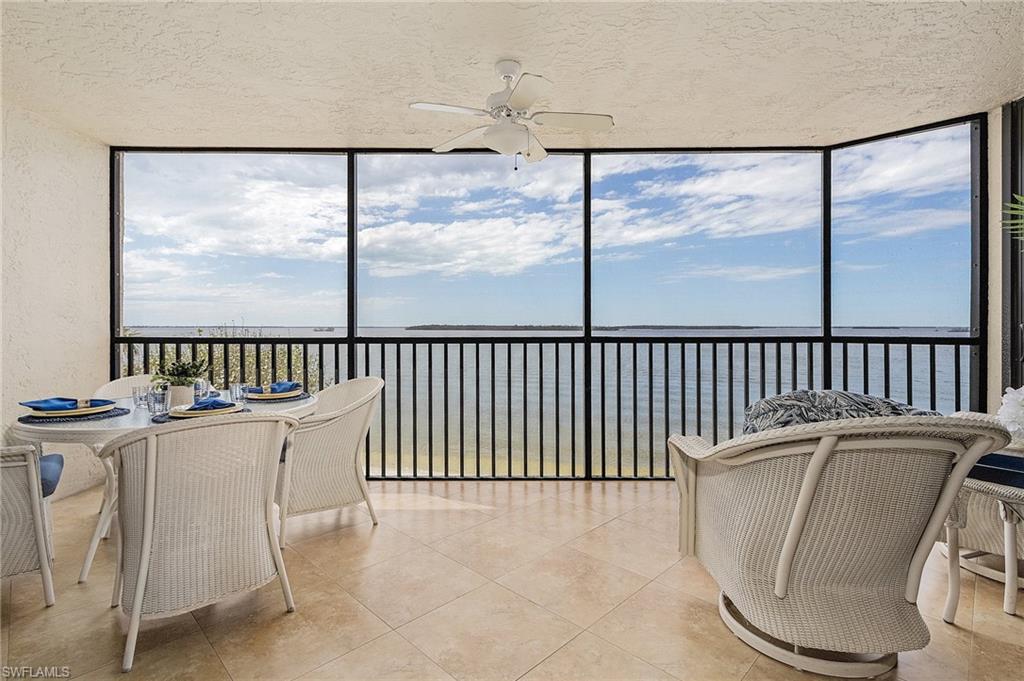 Sunroom with a water view, ceiling fan, and a wealth of natural light