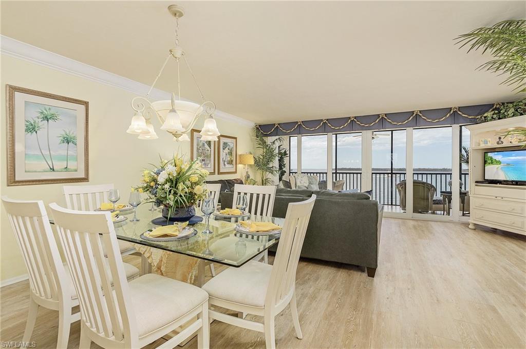 Dining space featuring ornamental molding, a notable chandelier, and hardwood / wood-style floors