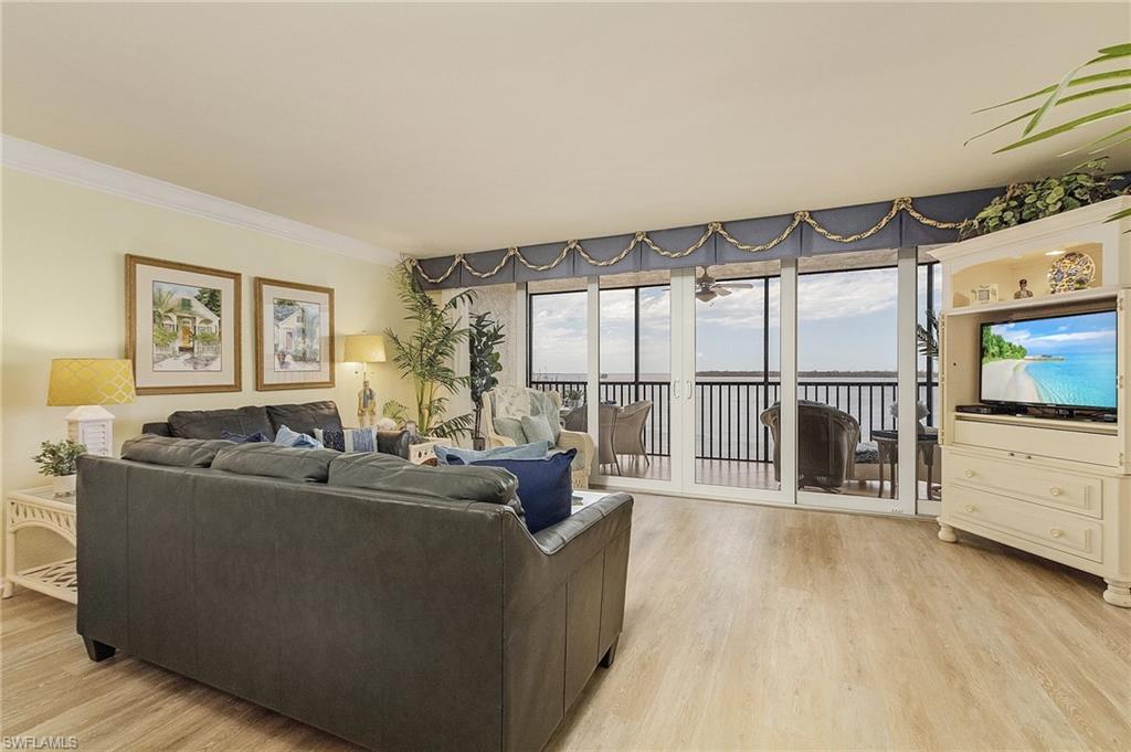 Living room featuring ornamental molding and light hardwood / wood-style flooring