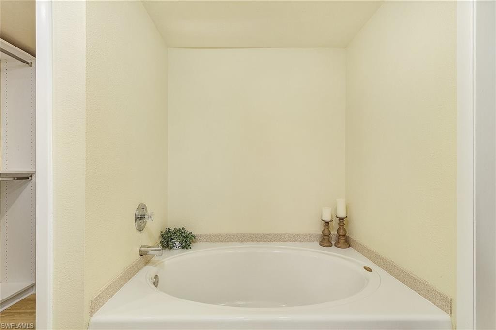 Bathroom with a tub to relax in and hardwood / wood-style flooring