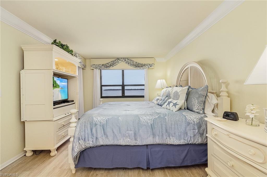Bedroom with ornamental molding and light hardwood / wood-style flooring