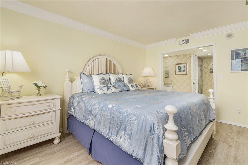 Bedroom featuring light hardwood / wood-style flooring, ornamental molding, and ensuite bath