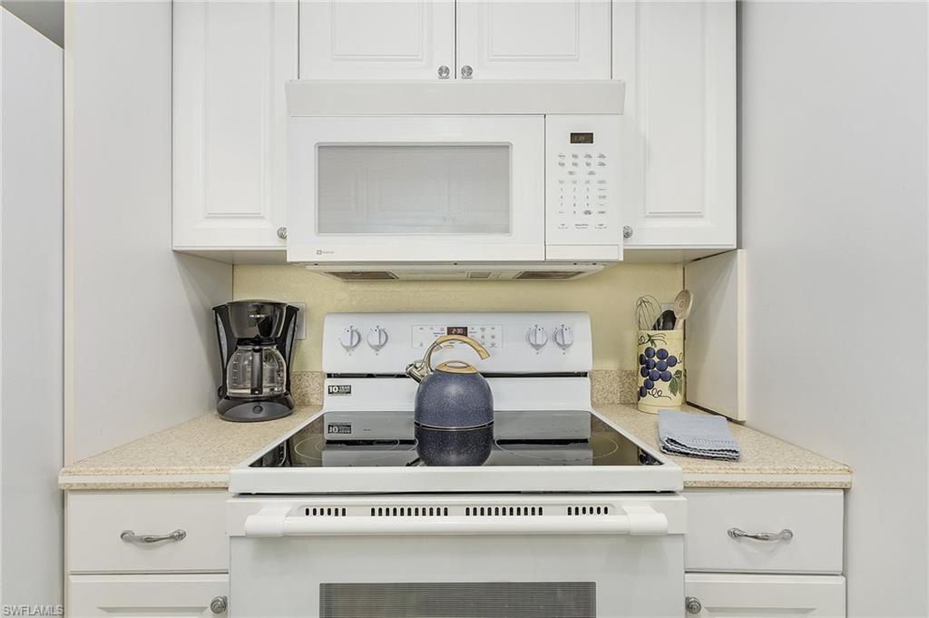 Kitchen featuring white cabinets and white appliances