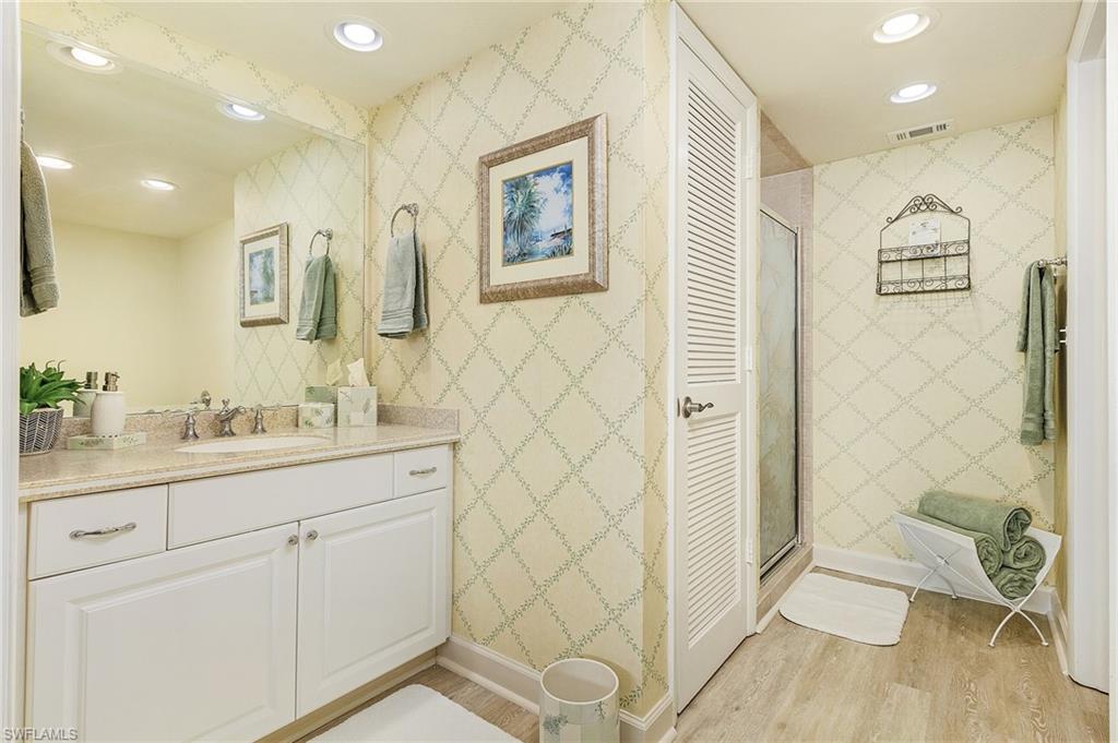 Bathroom featuring vanity, wood-type flooring, and a shower with shower door