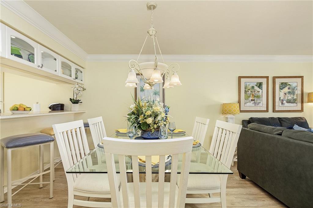 Dining room with light hardwood / wood-style flooring, a notable chandelier, and crown molding