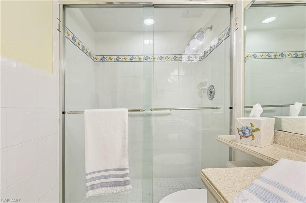 Bathroom with a shower with door, vanity, and toilet