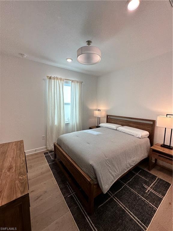 Bedroom featuring wood finished floors, a textured ceiling, and recessed lighting
