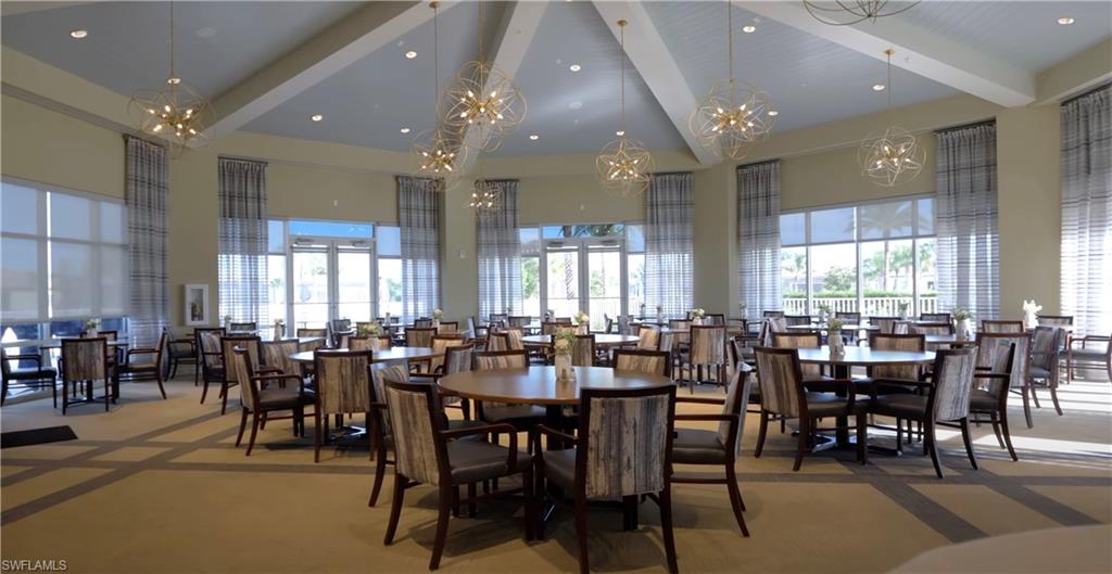 Dining room with a high ceiling, a chandelier, beamed ceiling, and healthy amount of natural light