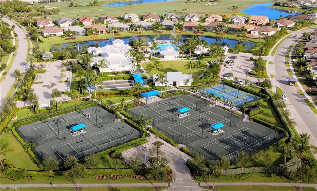 Aerial view of residential area featuring a nearby body of water and a local golf course